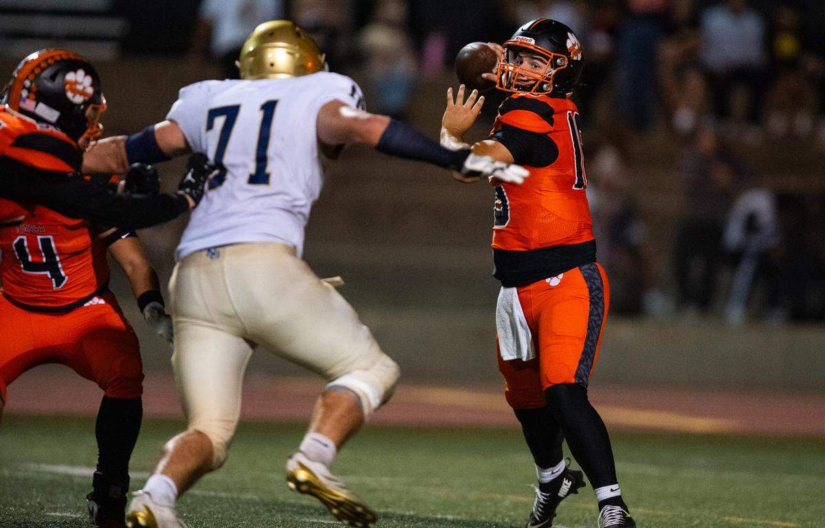 Roseville Tigers quarterback Mason Susnara (16) steps back to pass under pressure from Nevada Union Miners' Craig Statler (71) on Friday, Oct. 10, 2025, in Roseville.