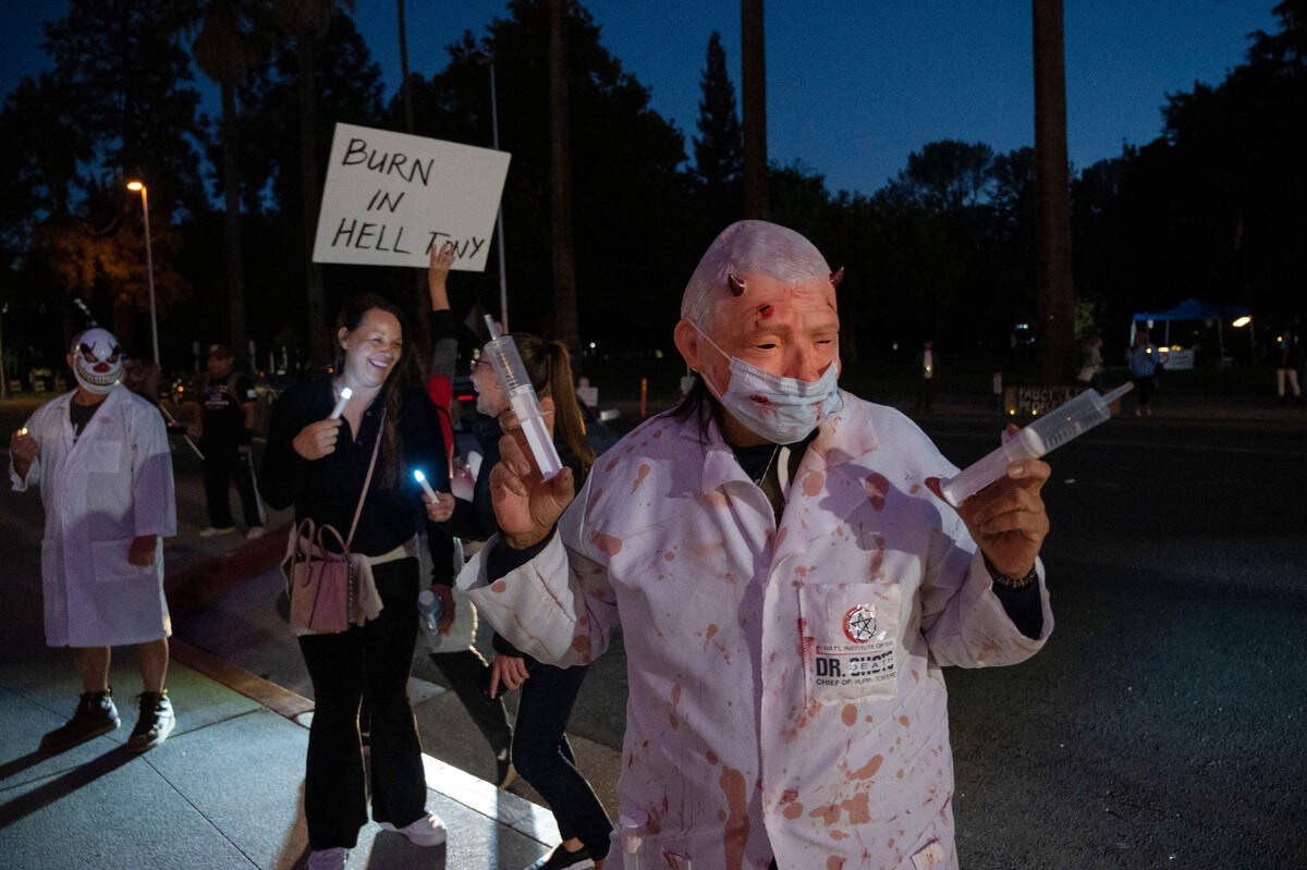 A group of people protest Dr. Anthony Fauci’s visit at the SAFE Credit Union Performing Arts Center on Wednesday, Oct. 11, 2023. Alicia Gonzalez, right, of Sacramento came dressed in a Fauci mask, equipped with over-sized syringes. The former chief medical advisor to the president was the featured guest in a local speaker series.