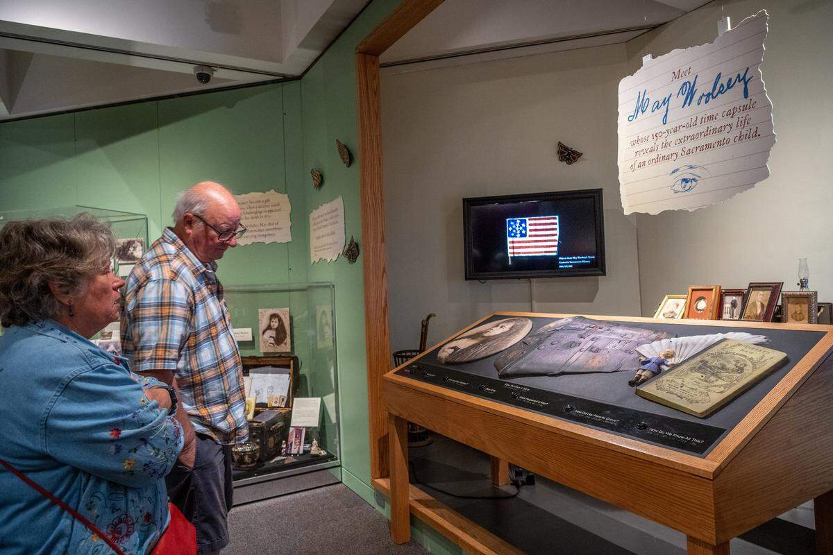 Roger Smithson and his wife, Beth, of Carmel, listen to narration at a tactile interactive exhibit about May Woolsey at the Sacramento History Museum on March 27. They said they had just taken a ghost tour in Old Sacramento, learned about her, and wanted to visit the museum to learn more.