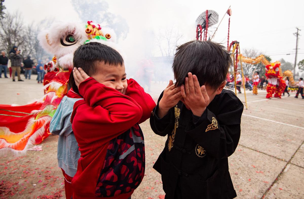 Children and adults protect their ears and eyes from the firecrackers during the traditional Chinese lion dance at the Sacramento Chinese of Indochina Friendship Association’s annual Lunar New Year celebration at the temple on Elder Creek Road on Saturday, Jan. 25, 2020, in Sacramento.