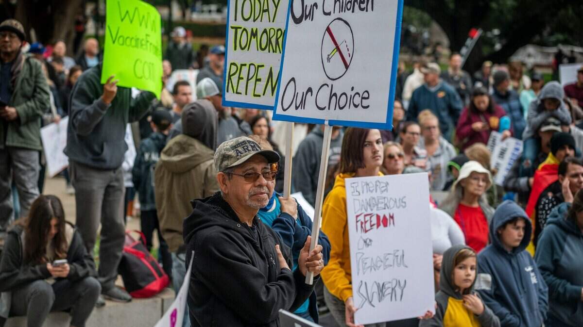 Mariano Martinez, 71, of Manteca on Monday, Nov. 15, holds a sign with a crowd of about 1,000 people who attended an Our Children, Our Choice rally on the north steps of ethnic State Capitol in Sacramento against the vaccine mandate for school children.