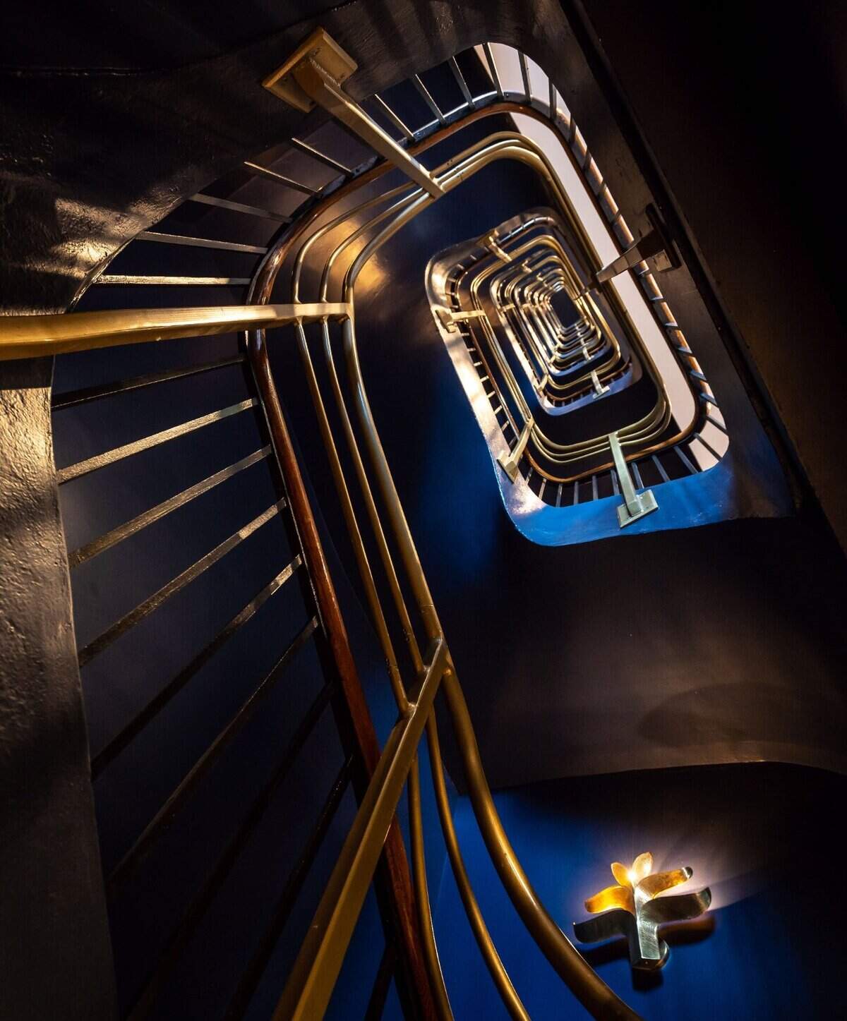 The Exchange Sacramento’s handcrafted staircase is seen while looking up the length of the interior inside the historic boutique hotel, part of the Curio Collection by Hilton. Tyler DeWittie, director of sales and marketing at The Exchange, said “wall sconces&nbsp;— as you go up the flight of stairs — are all unique to our hotel as well, one-of-a-kind pieces that you won’t find anywhere else.”