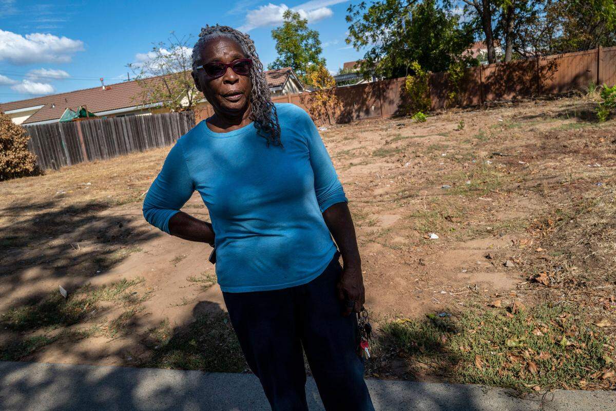 Wanda Clark stands in front of the empty lot where her home once stood in Oak Park on Tuesday. She said if she didn’t have a sister she would be sleeping in her car after the Bay Area Receivership Group caused her to demolish her house. Clark got to keep the land but she doesn’t have the money to rebuild.