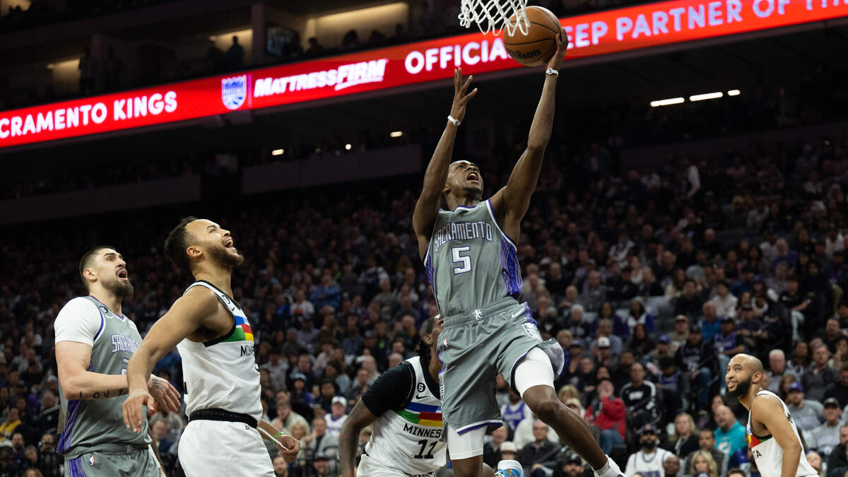 Sacramento Kings guard De’Aaron Fox (5) drives past Minnesota Timberwolves center Naz Reid (11) for a basket in the second quarter during a game at Golden 1 Center in Sacramento, Monday, March 27, 2023.