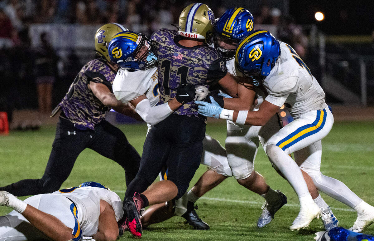 The Bradshaw Christian Pride's Mason Pisarski (11) is tackled by a wall of Sutter Huskies defenders, including Andrew Barker (33) and Justice White (15), in Vineyard on Friday.