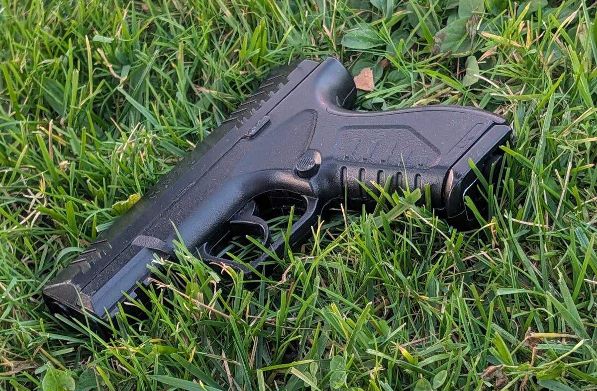 An imitation handgun lies in the grass near Exposition Parkway in Sacramento on Thursday, Jan. 25, 2026. Police say the weapon was recovered after officers fatally shot a suspected bank robber who led them on a foot chase in the Point West neighborhood.