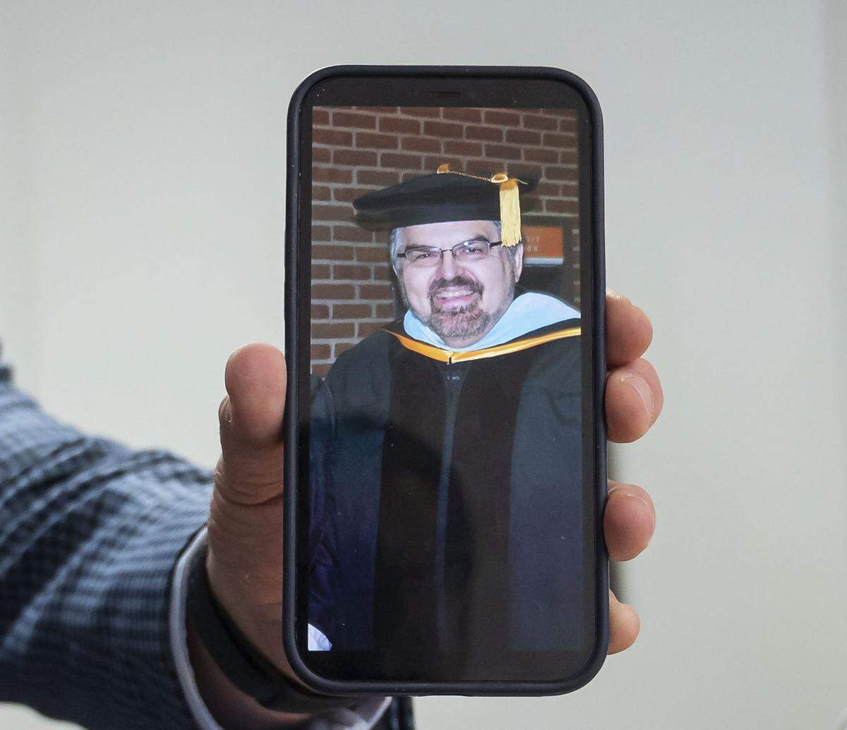 Scott Sorgea holds his phone showing a recent photo of former Capital Christian School coach and teacher Dave Arnold. Sorgea said during that time, Arnold routinely tied him up, blindfolded, gagged and subjected him to psychological abuse, eventually gratifying himself sexually.