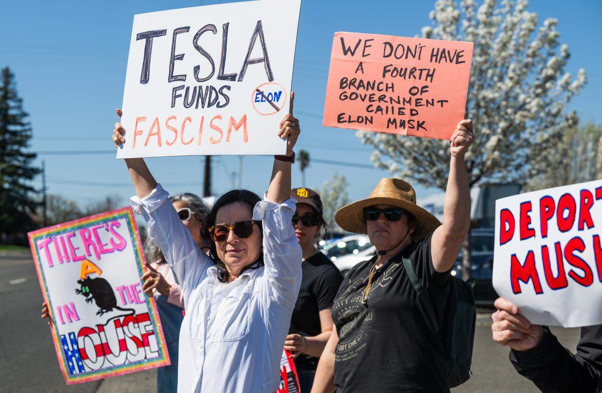 Demonstrators rally against Elon Musk at a Tesla dealership on Arden Way near Sacramento on Saturday, March 8, 2025. More than 100 people lined both sides of street to protest the role of the tech billionaire and Tesla CEO in the Trump administration.