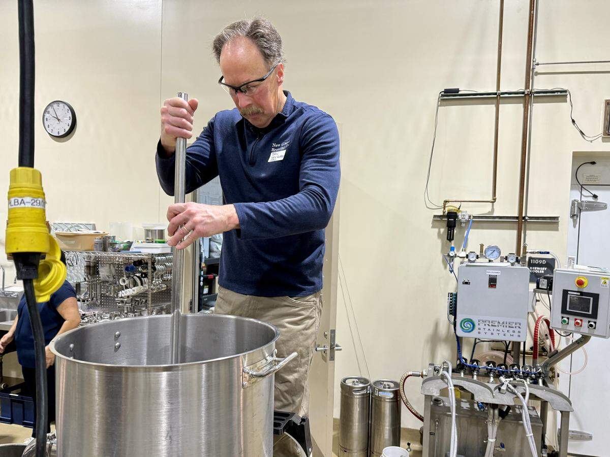 UC Davis brewing program alumnus Dan Carey stirs a pot of wort at the UC Davis pilot brewery on Thursday, Dec. 11, 2025. Carey founded New Glarus Brewing Co. in Wisconsin and returned for a reunion honoring program founder Michael Lewis.