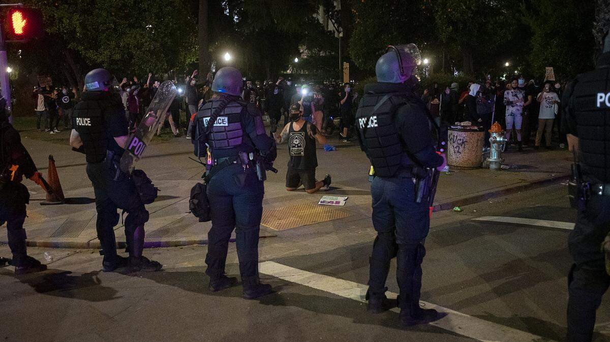 Demonstrators face off with Sacramento Police at L and 10th Streets during a protest over the death of George Floyd on Sunday, May 31, 2020 in Sacramento during the coronavirus pandemic. George Floyd died in Minneapolis Monday after being detained by police.