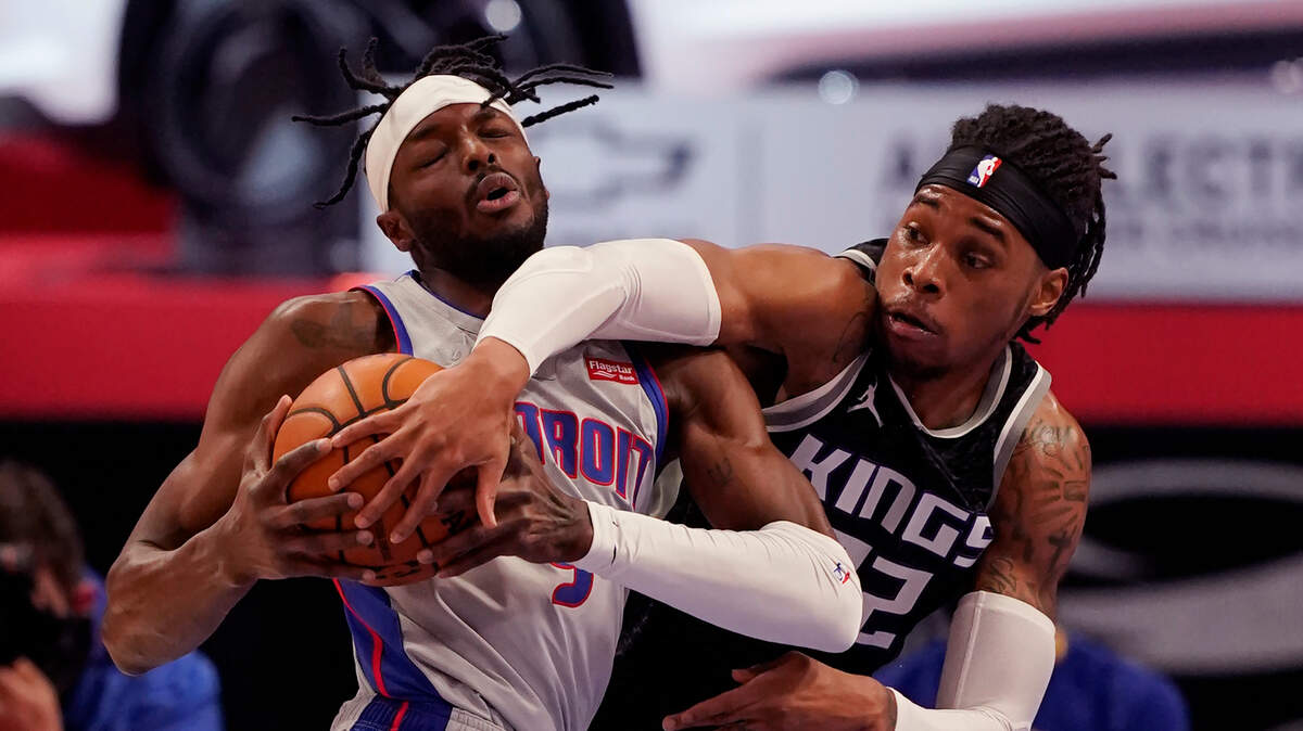 Sacramento Kings center Richaun Holmes (22) reaches in on Detroit Pistons forward Jerami Grant (9) during the first half of an NBA basketball game, Friday, Feb. 26, 2021, in Detroit. (AP Photo/Carlos Osorio)