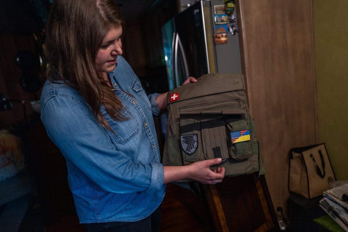 Alina Tyulyu holds a flak jacket on Tuesday that she wore while ducking for cover and in hiding while helping Ukrainian refugees during the war. She tells stories of friends killed and buildings, including a church, collapsing.