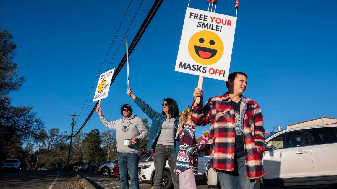 Leo Boswell, 10, right, holds a sign that says “free your smile” as he protests the mask requirement at Buckeye Elementary School in Single Springs on Monday, Jan. 24, 2022, with his parents, from left, Mike and Jill and sister Kassidy, 7. Both children attend the school.