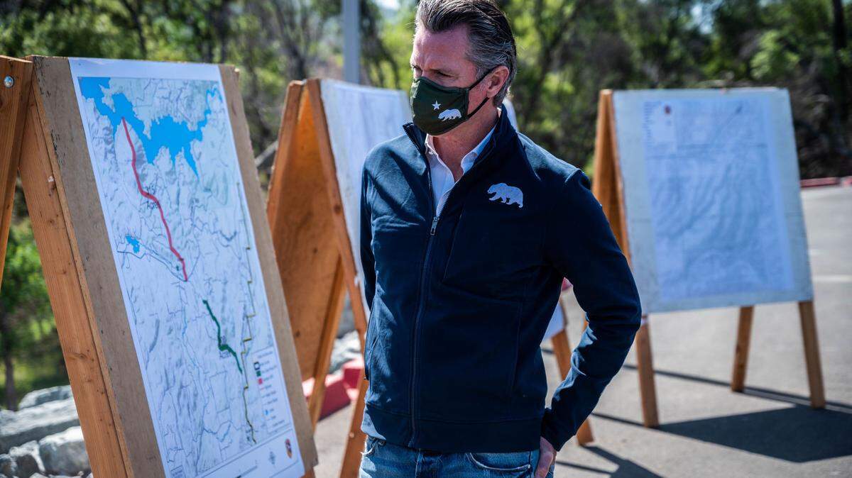 California Gov. Gavin Newsom looks at maps of fire history, vegetation management and fuel breaks before a press conference at Loafer Creek State Recreation Area near Oroville on Tuesday, April 13, 2021, the day he formally approved the spending more than a half billion dollars on wildfire prevention.