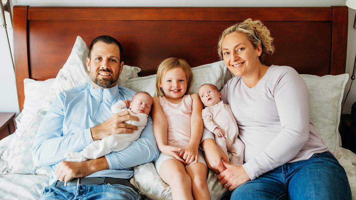 Jeremy Merz poses for a family picture with his wife Megan, 4-year-old daughter Jordyn and twins Taylor and Peyton at their home.