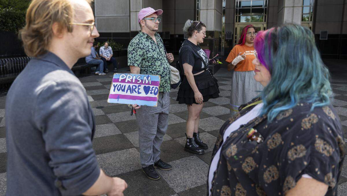 Ezra Kottler, of Sacramento, second from left, holds a sign in support of Prism Atica, an activist who was arrested for after taking a flag from an Immigration and Customs Enforcement facility in Stockton, after Atica's hearing at Robert T. Matsui U.S. Courthouse in Sacramento on Tuesday.