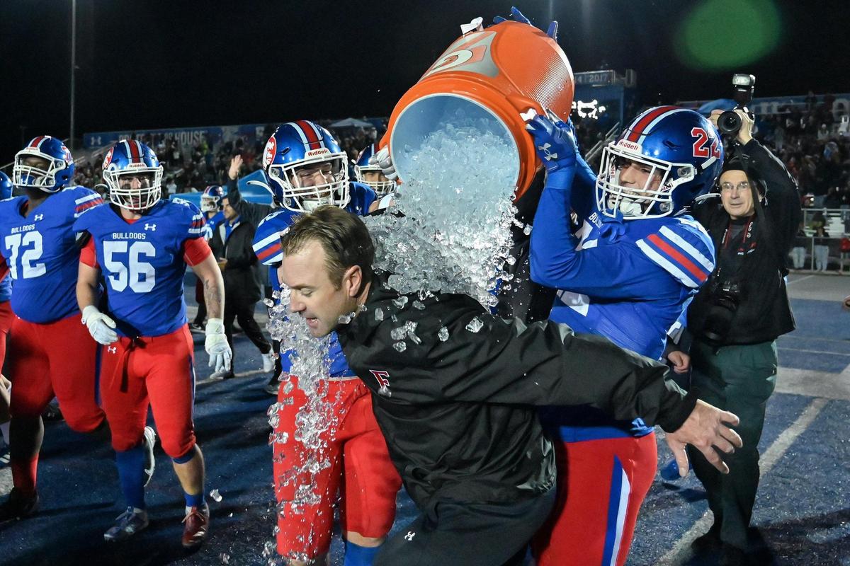 Folsom Bulldogs coach Paul Doherty gets doused with ice after winning the 2023 CIF Northern California Division 1-A championship against the Pittsburg Pirates.