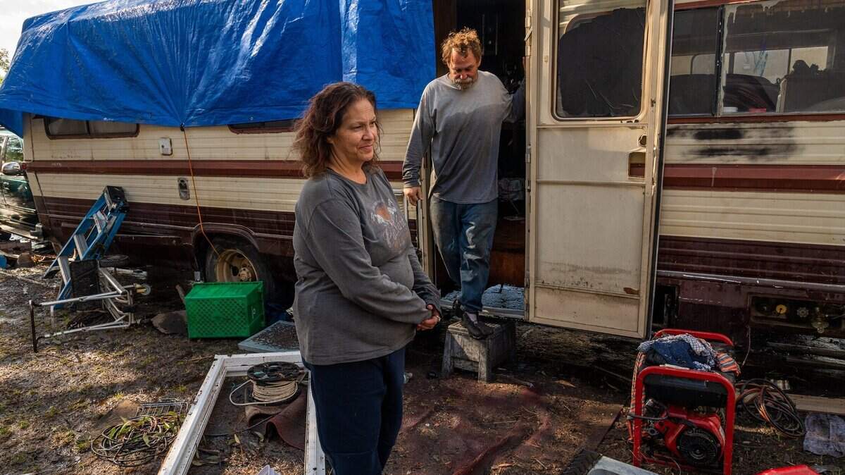 Rebecca Holsey, left, talks Monday, Oct. 25, 2021, about being rescued with a raft by the fire department Sunday nigh after heavy rains flooded Pell Drive in Sacramento. Her partner Keith Jensen, right, who was also rescued, still wears clothing showing the floodwater’s hight. Holsey said she considered escaping through the window of her RV before the rescue.