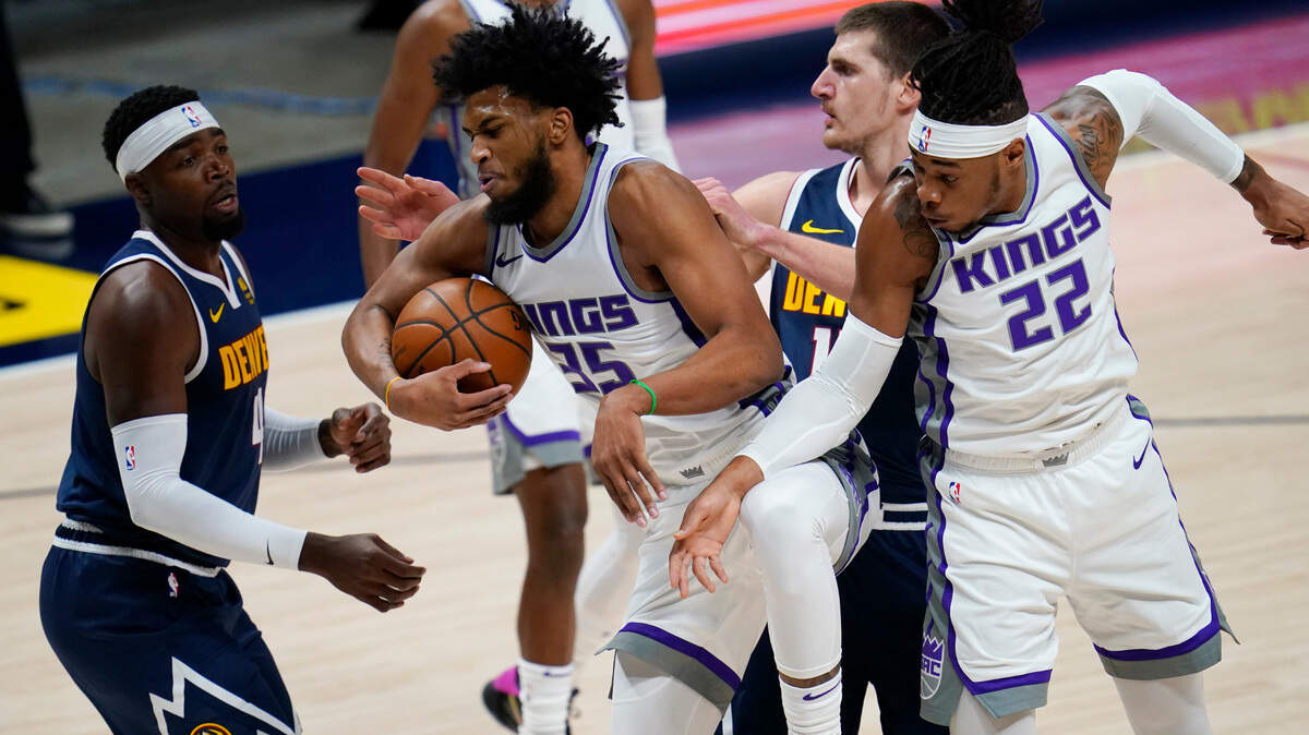 Sacramento Kings forward Marvin Bagley III, second from left, pulls in a rebound as Denver Nuggets forward Paul Millsap, left, and center Nikola Jokic, second from right, defend, near Sacramento center Richaun Holmes, right, during the first half of an NBA basketball game Wednesday, Dec. 23, 2020, in Denver. (AP Photo/David Zalubowski)
