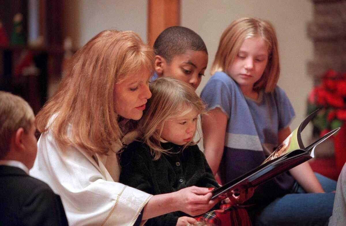 Faith Whitmore, during her time as pastor of the Florin United Methodist Church in Sacramento, reads to children from the congregation in 1999. Whitmore, who became the Sacramento Regional Family Justice Center first CEO, announced her retirement on April 3, 2024.