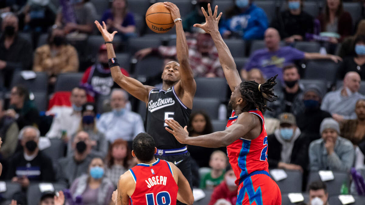 Sacramento Kings guard De’Aaron Fox (5) grabs a rebound between Detroit Pistons guard Cory Joseph (18) and center Isaiah Stewart (28) during the second half of an NBA basketball game in Sacramento, Calif., Wednesday, Jan. 19, 2022. The Pistons won 133-131. (AP Photo/José Luis Villegas)