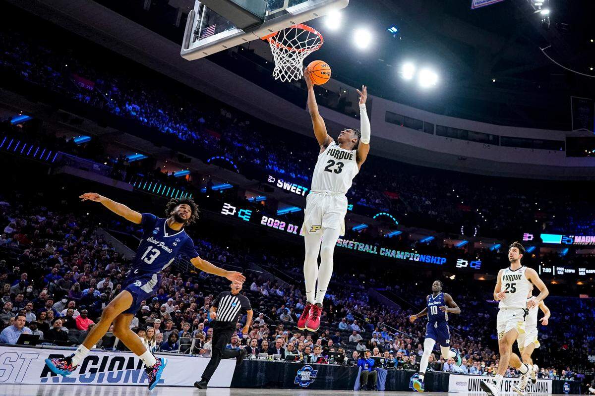 Purdue ‘s Jaden Ivey, center, goes up for the shot as Saint Peter’s Isiah Dasher, left, looks on during the first half of a college basketball game in the Sweet 16 round of the NCAA tournament, Friday, March 25, 2022, in Philadelphia. (AP Photo/Chris Szagola)