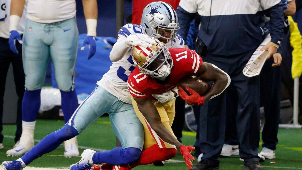 San Francisco’s Brandon Aiyuk is tackled by Dallas’ Anthony Brown on Sunday.