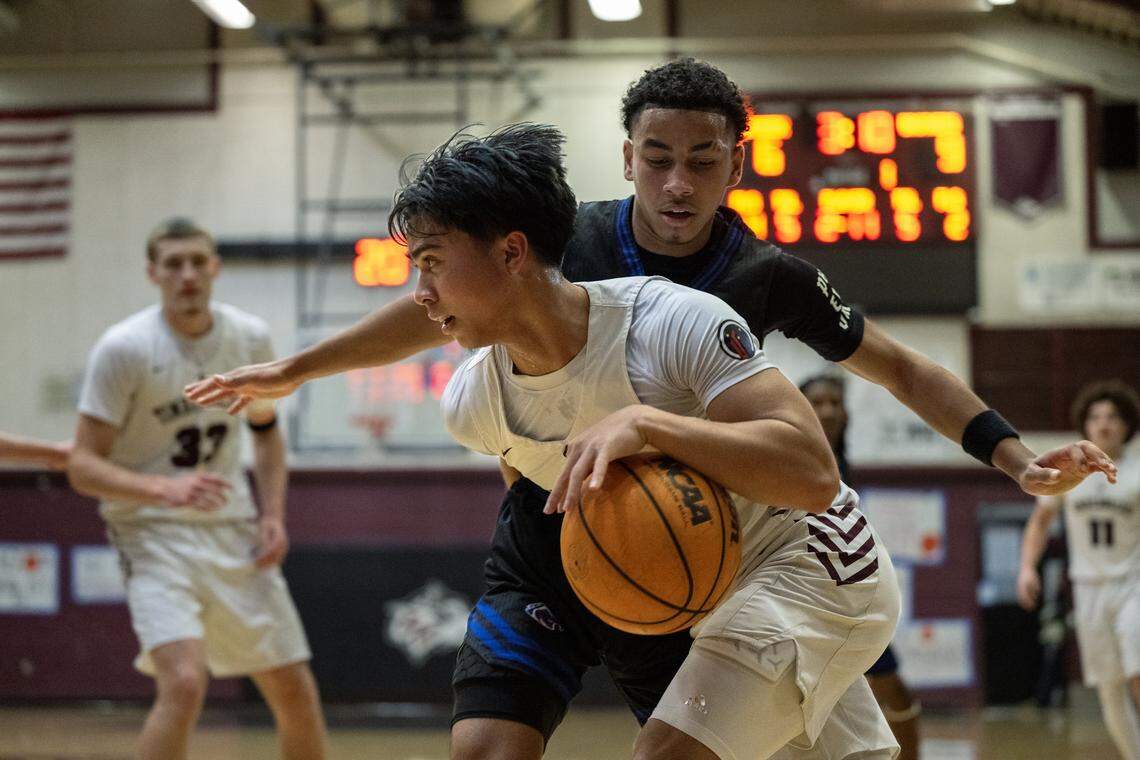 The Woodcreek Timberwolves' Zach Bualat (5) dribbles past the Christian Brothers Falcons' Joaquin Lucero-Mattis (5) in the first half on Thursday in Roseville.