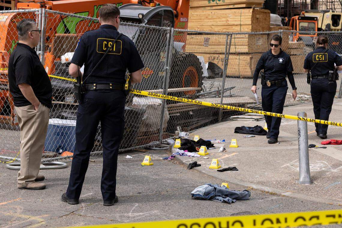 Sacramento police crime scene investigators stand near evidence markers near the Cathedral of the Blessed Sacrament in downtown Sacramento after the gang shootout that killed six on April 3.