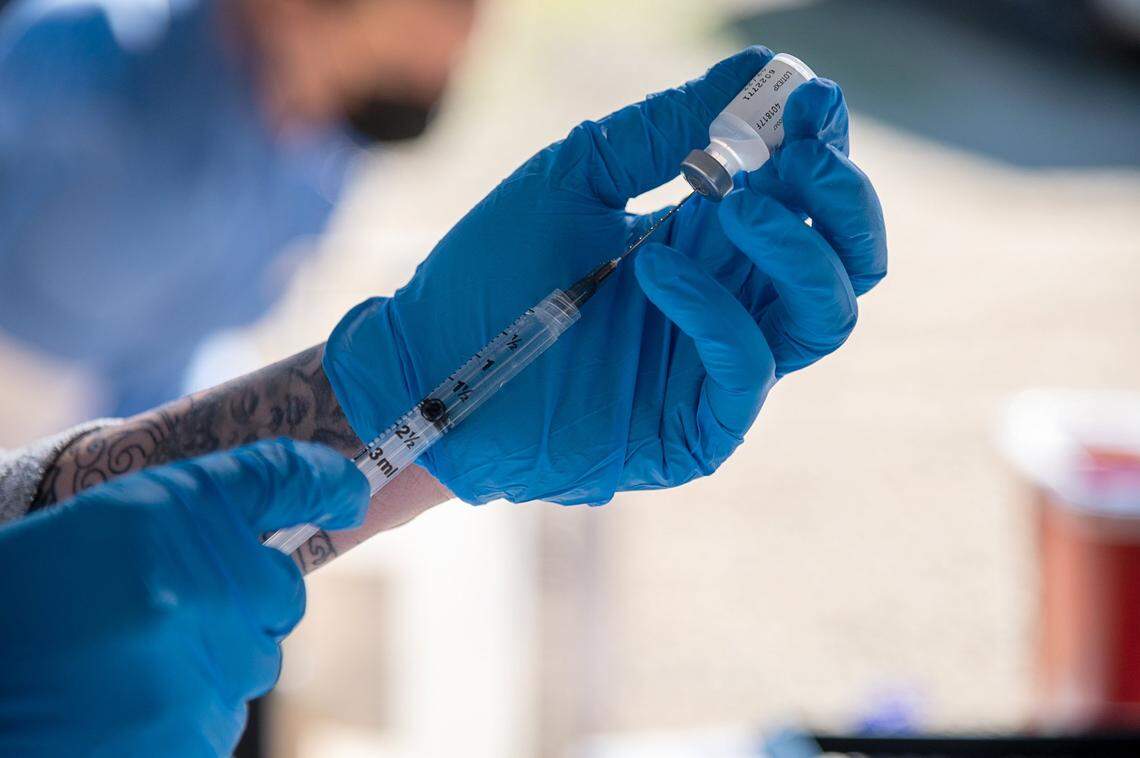 Yolo County EMS Administrator Kristin Weivoda prepares to vaccinate a farmworker for COVID-19 on Wednesday, Feb. 17, 2021 at an organic farm near Esparto. Not all counties have begun vaccinating essential workers. Each countys vaccine rollout plan varies depending on the county and its supply of doses.