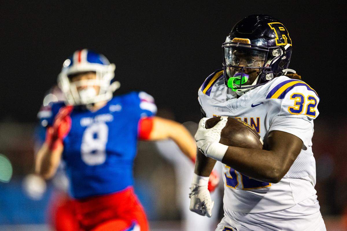 Riordan Crusaders running back Adonyae Brown (32) runs past Folsom Bulldogs outside linebacker Dylan Wolfe (8) on his way to a 70-yard touchdown in the first half of the CIF Northern California Regional Division 1-AA football championship game in Folsom on Friday.