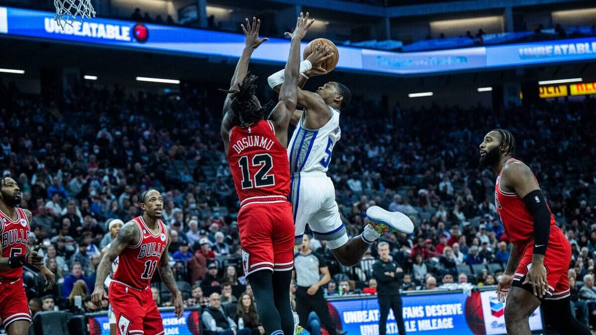 Sacramento Kings guard De’Aaron Fox (5) goes to the basket against the Chicago Bulls guard Ayo Dosunmu (12) on Sunday, Dec. 4, 2022, during an NBA basketball game at Golden 1 Center in Sacramento.