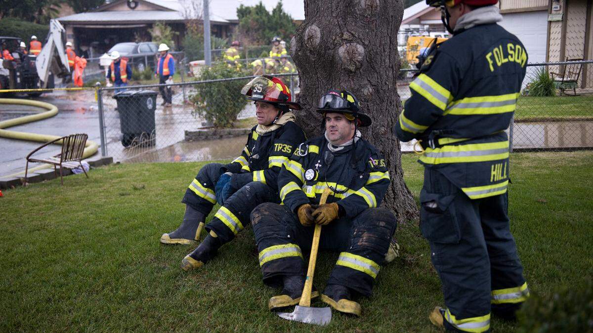 Captain Calvin Howard, left, and Bill Woodward, with Folsom Fire Department, take a break after fighting a fire at a home that exploded Wednesday, December 24, 2008. The Folsom City Council approved hiring eight firefighters at its meeting July 8, 2025.
