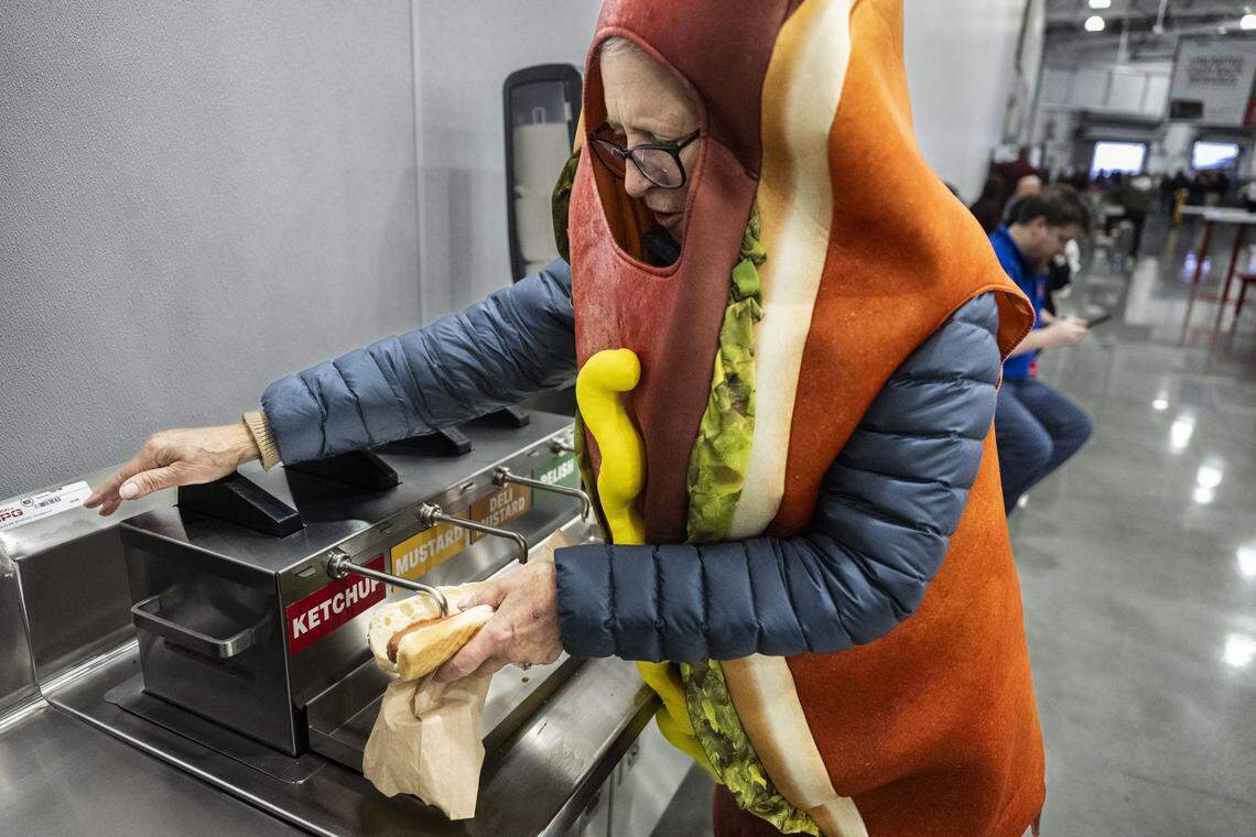 Costumed customer Cody Ball, of Napa, fixes a hot dog during the grand opening of the Costco on Baseline Road in Roseville on Friday. Ball was attending her third Costco opening.  