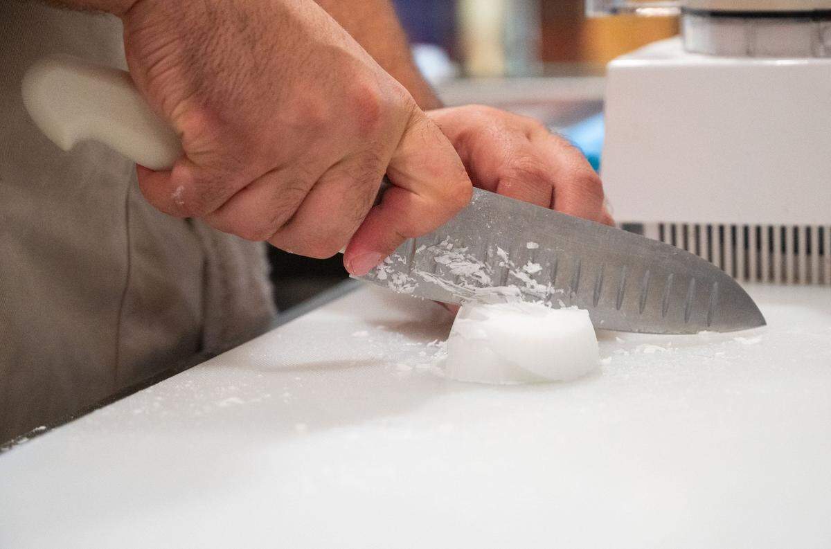 Purple Tree Café employee Jacob Amato slices ingredients before mixing them together in a food processor earlier this month at the cafe, which is housed inside the MIND Institute at the UC Davis Medical Center in Sacramento. The café’s recipes are written in a grid format that organizes steps by their instruments, ingredients and instructions so that all employees can easily complete tasks.