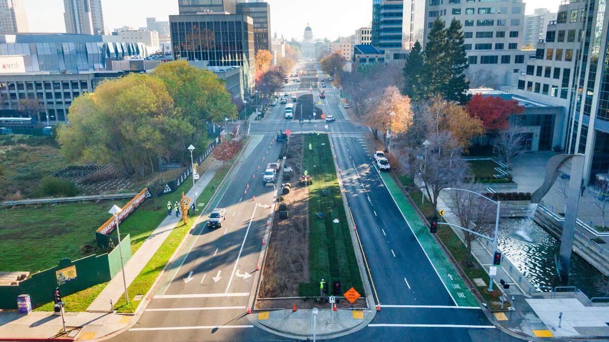 Workers lay sod in the median of Capitol Mall on Tuesday, Dec. 3, 2024, as part of a beautification project. Sacramento is prepared to welcome state employees back under Newsom’s four-day hybrid order, boosting downtown vitality and foot traffic beginning July 1.