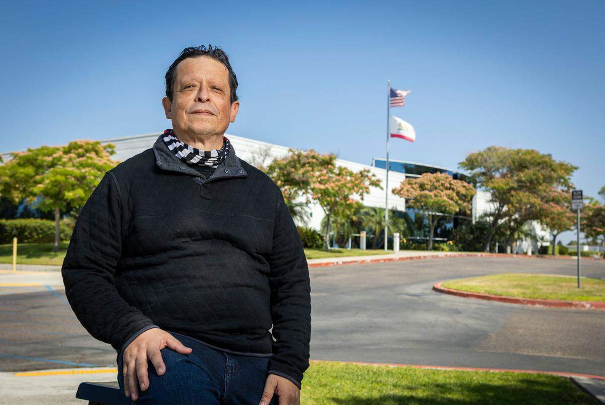 Ben De La Torre, who works as a front-line worker for the Employment Development Department in Chula Vista, sits outside its offices in June. Last year, he tripled his income in overtime to process unemployment insurance claims.