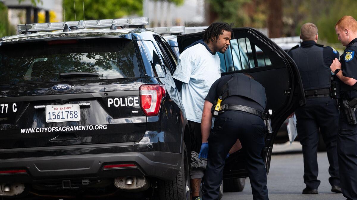 A man is detained by the Sacramento Police Department on Tuesday, March 31, 2020, after a standoff on the 3500 block of San Jose Way in Oak Park after an alleged carjacking.