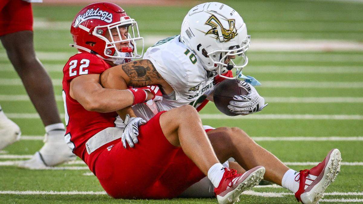 Fresno State defensive back Camryn Bracha pulls down Sacramento State’s Danny Scudero on a play during their game at Valley Children’s Stadium on Saturday.