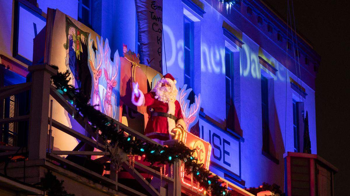 Santa and his reindeer make an appearance in a live dramatization on a balcony above K Street in historic Old Sacramento during a Theatre of Lights performance.