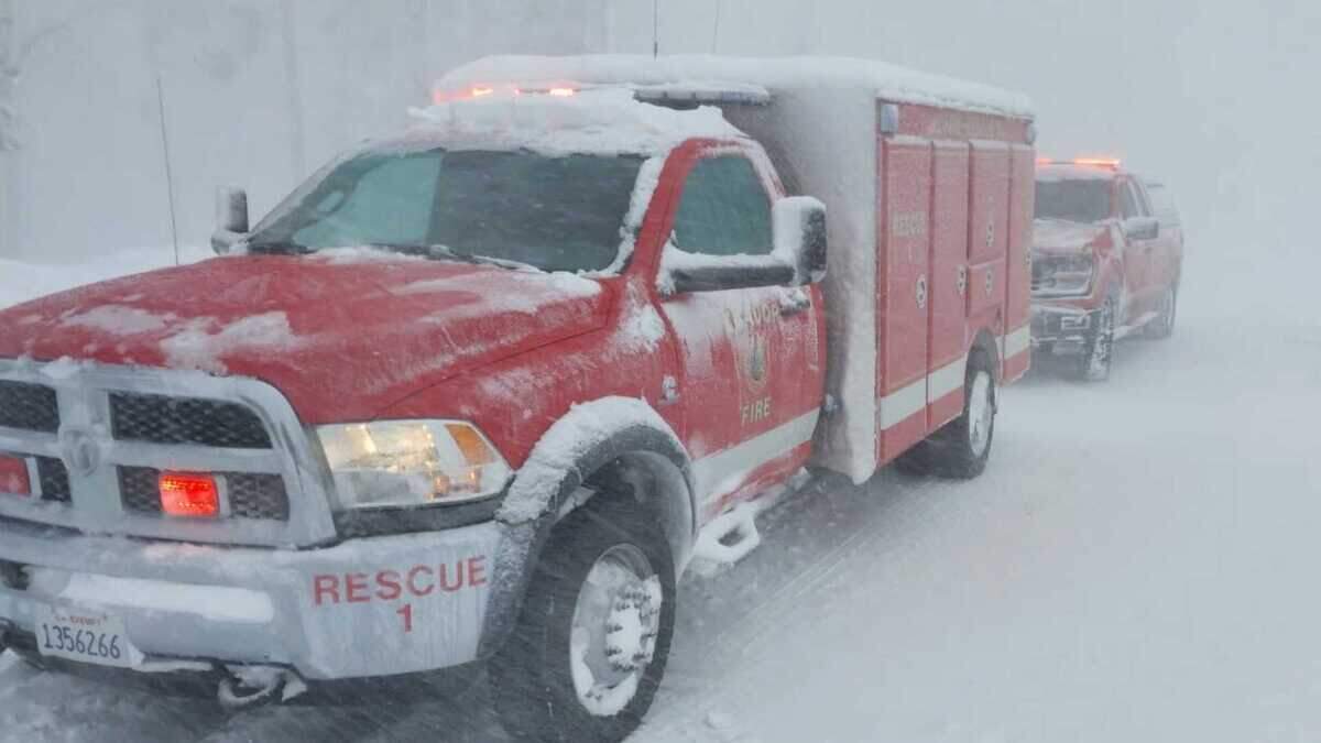 Rescue trucks from the Amador Fire Protection District sit along snow-covered Mormon Emigrant Trail on Tuesday in El Dorado County, as heavy snow and whiteout conditions blanket the area. Crews from Amador County assisted El Dorado County agencies in locating three people who had been stranded in the remote area during a powerful Sierra storm.
