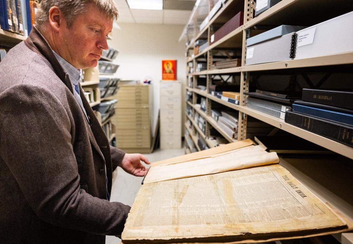 Alex Vassar, the California State Library’s chief spokesperson, looks at the first edition of the Sacramento Union on Thursday during a tour of the library vault. Published on March 19, 1851, the newspaper was originally known as the Daily Union.