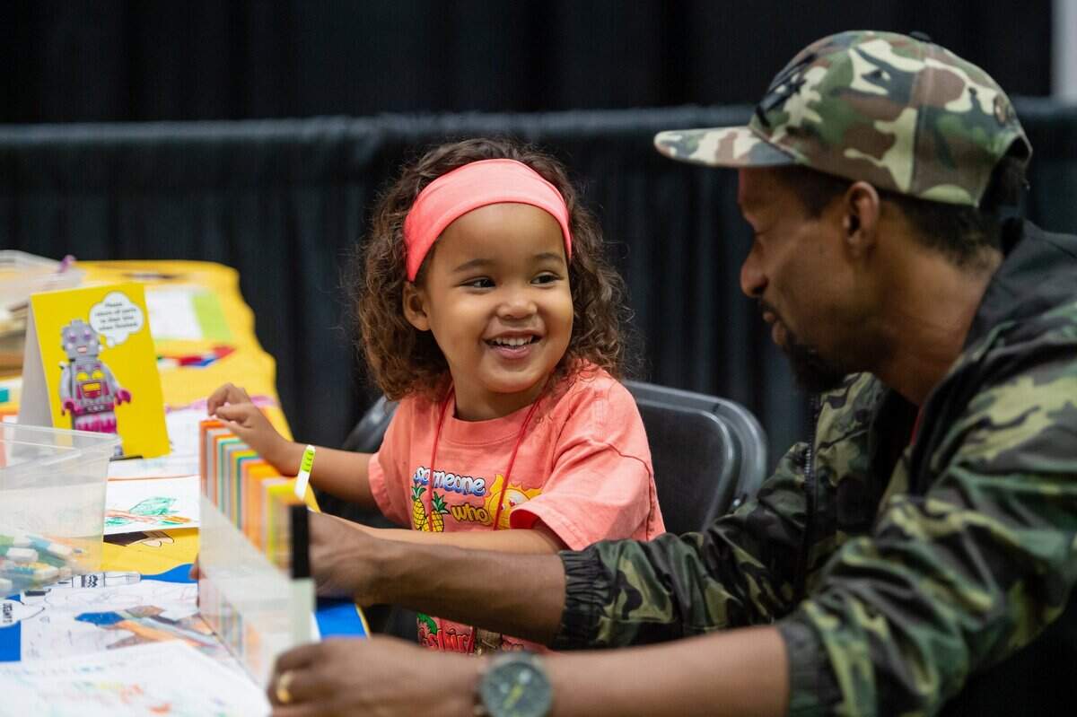 Myles, 5, smiles at his uncle Dell Angus while coloring at the Lego Brick Fest Live on Sunday, Oct. 2, 2022, at SAFE Credit Union Convention Center in downtown Sacramento.