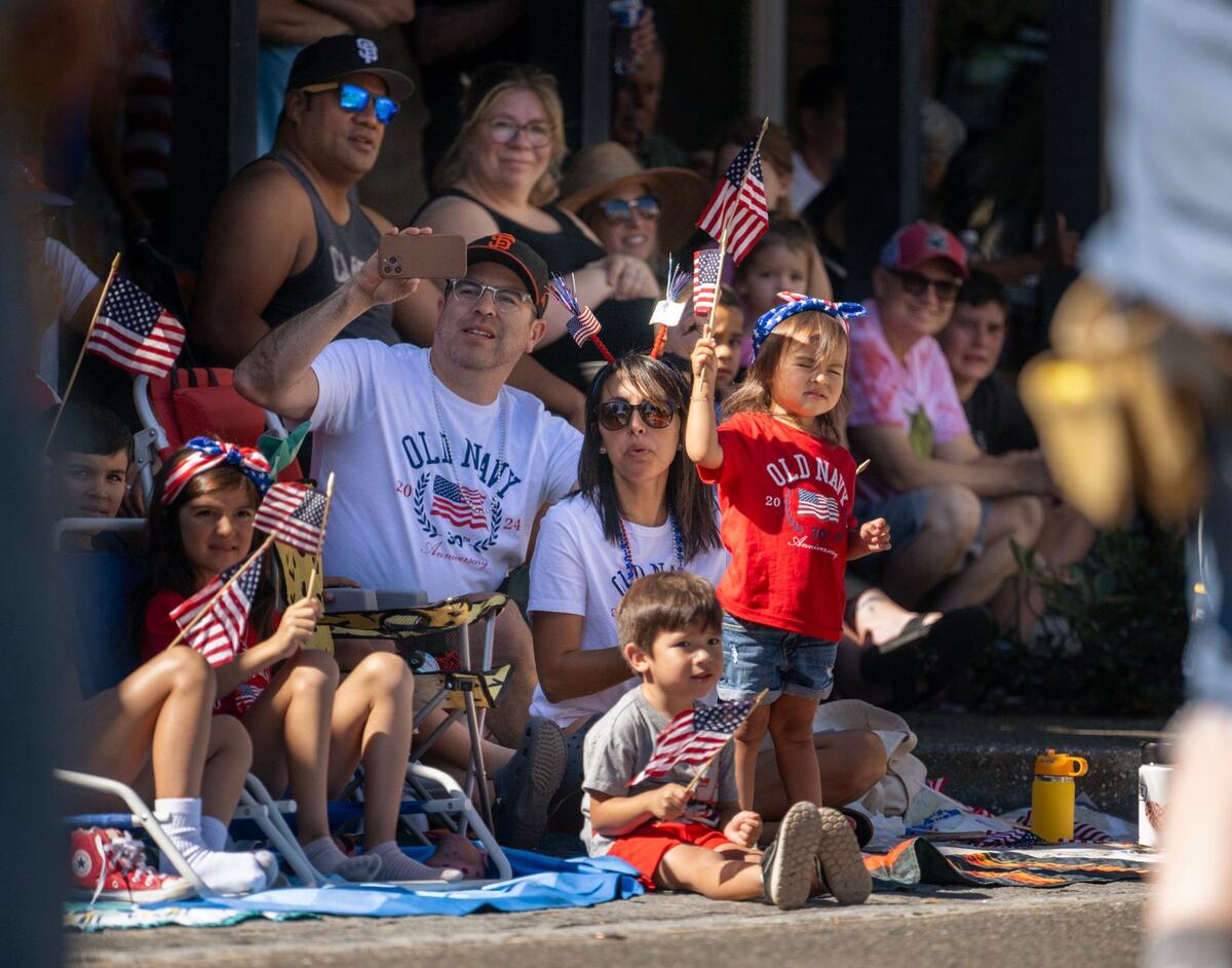 Locals wave American flags during Folsom’s Annual Parade on Historic Sutter Street on Saturday.