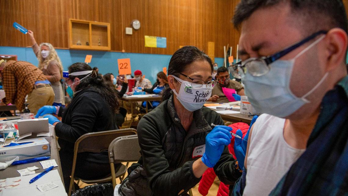 Doreen Beyer gives the Pfizer corornavirus vaccine to Quyen Voi at Burbank High School on Tuesday, April 13, 2021. The clinic had to switch from the Johnson & Johnson vaccine after U.S. health officials paused its use Tuesday because a rare blood clotting disorder was found in six recipients.