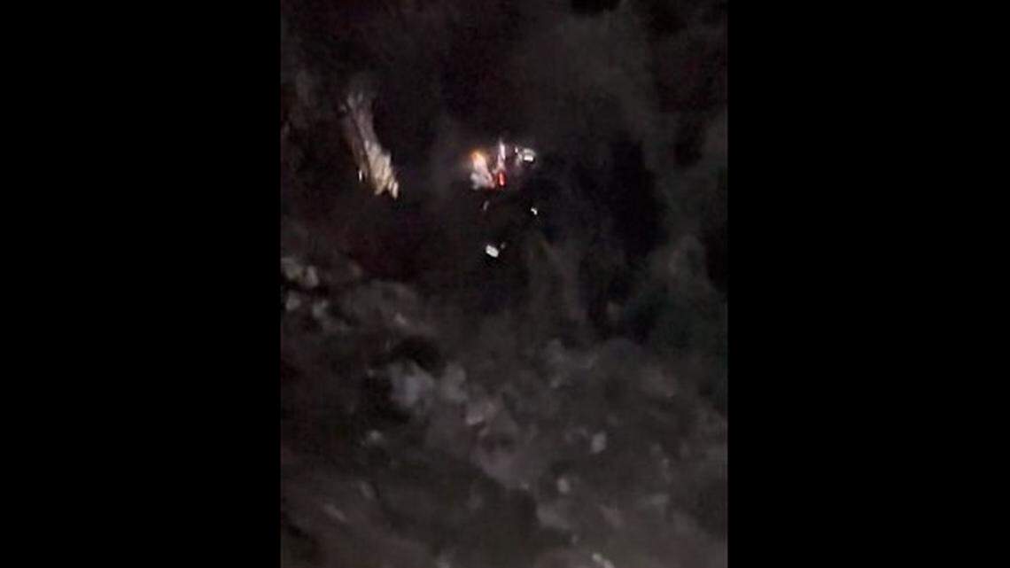 A helicopter hoists a rescuer and an injured driver to safety after a vehicle fell from a 400-foot cliff at Mount Wilson in California.