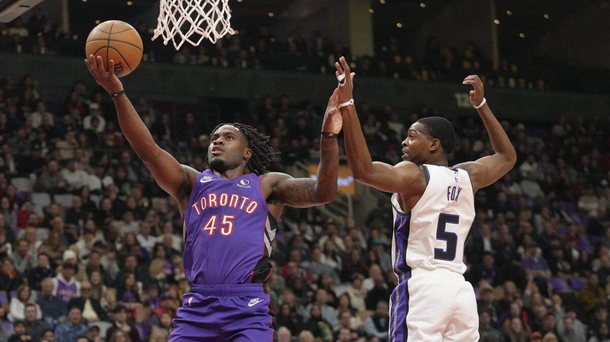 Nov 2, 2024; Toronto, Ontario, CAN; Toronto Raptors guard Davion Mitchell (45) goes up to make a basket against Sacramento Kings guard De'Aaron Fox (5) during the first half at Scotiabank Arena. Mandatory Credit: John E. Sokolowski-Imagn Images