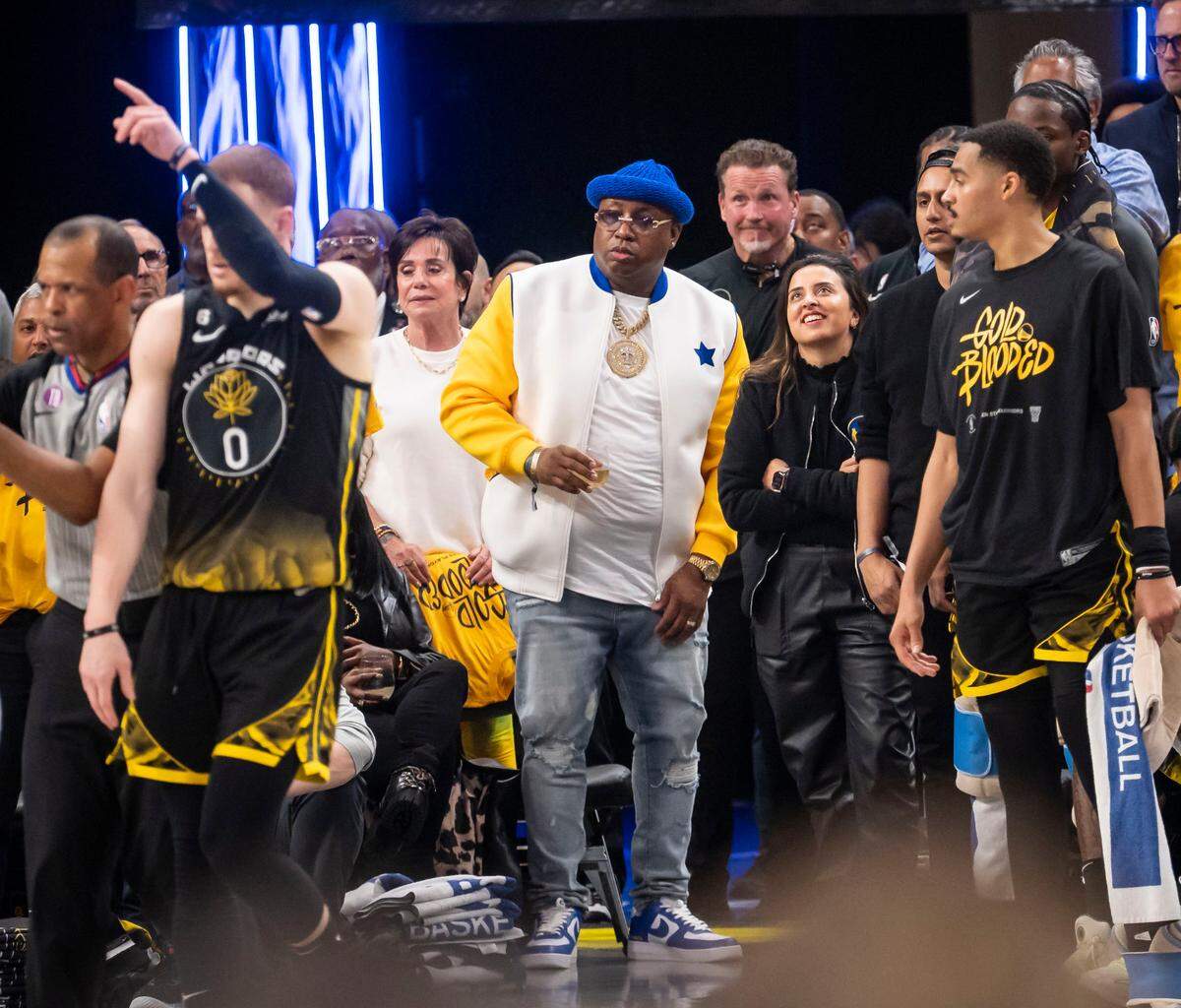Rapper Earl “E-40” Stevens, center, roots for his team, the Golden State Warriors, against the Sacramento Kings in the second half of Game 3 of the first-round NBA playoff series at Chase Center in San Francisco on April 20, 2023.