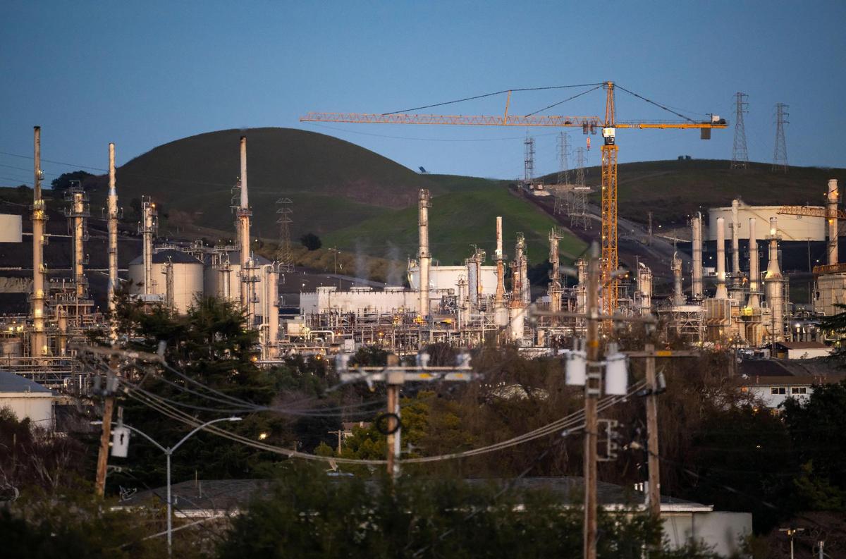 A crane used in construction on new facilities to process renewable fuels towers over the Phillips 66 refinery equipment and the small Contra Costa County community of Rodeo in January as the site transitions away from processing crude oil.