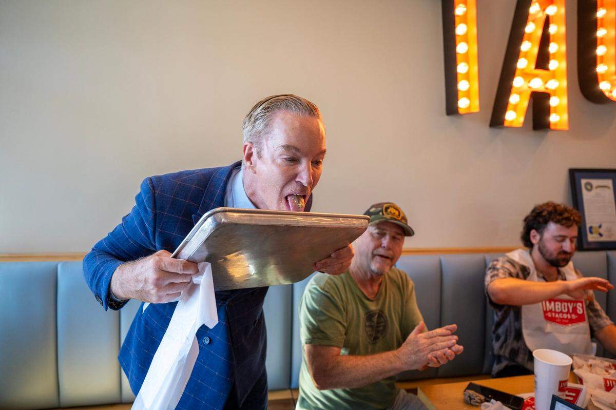 ABC’s Mark S. Allen licks his tray after finishing first in a taco eating contest to celebrate the 70 years of Jimboy’s Tacos at the restaurant’s Folsom location on Wednesday.